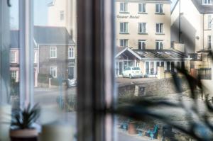 a window with a view of a street and a building at Coppet Cove - 2 Bedroom Apartment - Saundersfoot in Saundersfoot