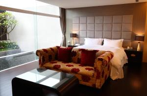 ein Schlafzimmer mit einem Bett, einem Sofa und einem Fenster in der Unterkunft Elan-Motel in Wujie