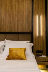 a bed with a yellow pillow on top of it at Kraal Hotel Vlore in Vlorë