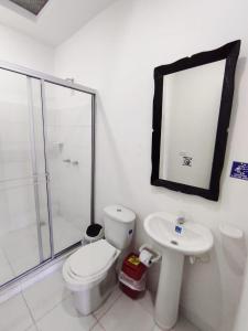 Un baño con inodoro, lavabo y ducha. en Hotel Fermín, en Santa Rosa de Cabal