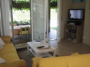 un soggiorno con divano, tavolo e TV di Holiday home in Pacengo - Gardasee 21959 a Ronchi