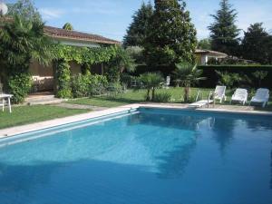 una piscina con due sedie e una casa di Holiday home in Pacengo - Gardasee 21959 a Ronchi
