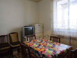- un salon avec une table et une télévision dans l'établissement Apartment in Omisalj - Insel Krk 39736, à Omišalj