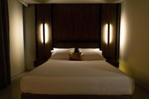 a bedroom with a large white bed with two lights at Kraal Hotel Vlore in Vlorë