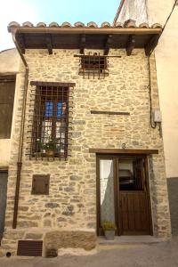 a stone house with two windows and a door at Casa Rural El Portillo in Cantavieja