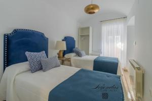 um quarto com 2 camas em azul e branco em Casa Leyendas de Cáceres - en plena zona monumental em Cáceres