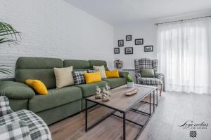 uma sala de estar com um sofá verde e uma mesa de centro em Casa Leyendas de Cáceres - en plena zona monumental em Cáceres