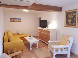 uma sala de estar com um sofá amarelo e uma televisão em Apartments in Zadar - Zadar Riviera 40411 em Zadar