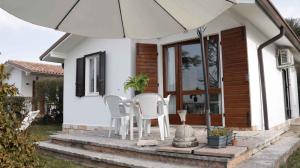 patio z białymi krzesłami i parasolem w obiekcie Apartment in Bardolino - Gardasee 39739 w mieście Bardolino