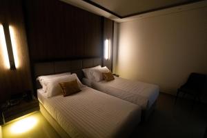 two beds in a hotel room with lights at Kraal Hotel Vlore in Vlorë