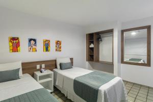 Citi Hotel Express Caruaru في كاروارو: غرفة فندقية بسريرين ونافذة