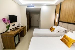 a hotel room with two beds and a television at Kraal Hotel Vlore in Vlorë
