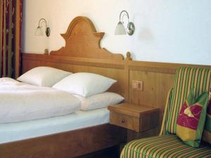 a bedroom with a bed and a chair and a lamp at Pension Seeblick in Attersee am Attersee