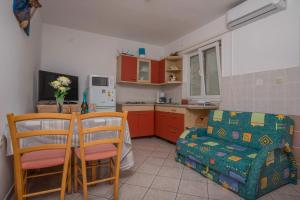 een keuken met een tafel en stoelen en een bank bij Apartment in Dramalj 41384 in Klanfari