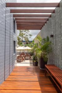 a wooden walkway with a bench and some tables at Citi Hotel Residence Caruaru in Caruaru