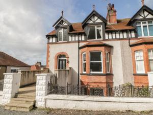 una casa vieja con una valla delante de ella en 4 Tan Y Bryn Road, en Llandudno