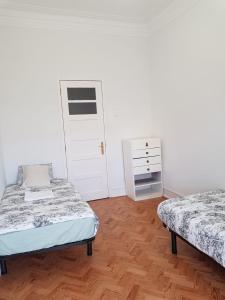 a bedroom with two beds and a dresser at Rainbow Guest House in Lisbon