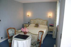 una camera da letto con un letto e un tavolo con un libro sopra di Domaine De Kerstinec/Kerland a Riec-sur-Bélon