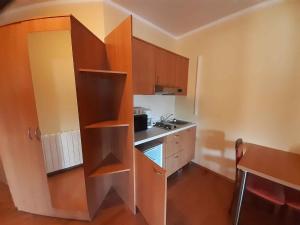 uma pequena cozinha com armários de madeira e um lavatório em Studio in Funtana/Istrien 40430 em Funtana