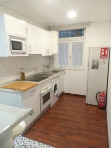 uma cozinha com armários brancos e um forno com placa de fogão em FRANPAVI Aviles em Avilés