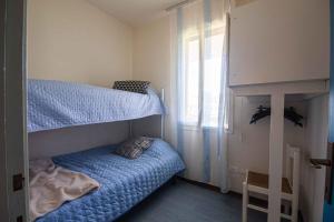 a bedroom with a bunk bed with a blue bed at Holiday home Porto Santa Margherita 40296 in Porto Santa Margherita di Caorle +16 photos