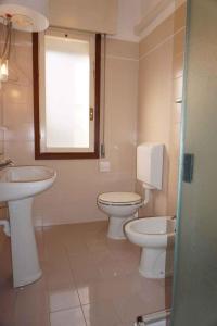 a bathroom with two toilets and a sink at Apartment in Porto Santa Margherita 40295 in Porto Santa Margherita di Caorle