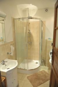 La salle de bains est pourvue d'une douche et d'un lavabo. dans l'établissement Dom nad Strugą, à Słuchowo