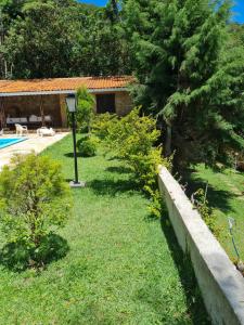 un patio con una casa, una piscina y árboles en Chale em Atibaia en Atibaia