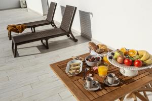 Pé no Campo Suites and Villa في Carvalhal: طاولة عليها صحن من الفواكه وغيرها من الأطعمة