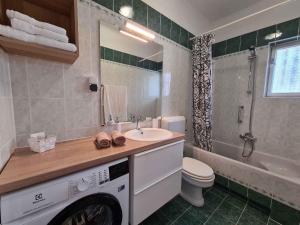 a bathroom with a sink and a washing machine at Apartments in Moscenicka Draga 34827 in Mošćenička Draga