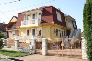 ein großes gelbes Haus mit Tor und Zaun in der Unterkunft Apartments in Zalakaros 38691 in Zalakaros