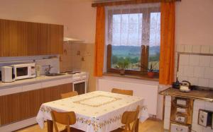 eine Küche mit einem Tisch, einer Mikrowelle und einem Fenster in der Unterkunft Holiday home in Ruda 2035 in Ruda