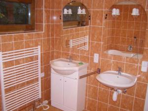 La salle de bains carrelée est pourvue d'un lavabo et d'un miroir. dans l'établissement Holiday home in Ruda 2035, à Ruda