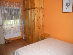 1 dormitorio con 1 cama y armario de madera en Apartment in Balatonöszöd 20195, en Balatonőszöd