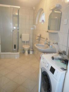 W łazience znajduje się pralka i umywalka. w obiekcie Holiday home Cserszegtomaj/Balaton 39729 w mieście Cserszegtomaj