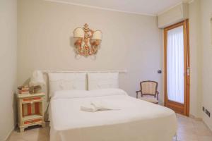 Habitación blanca con cama blanca y lámpara de araña. en Apartment in Poggibonsi/Toskana 38410 en Poggibonsi