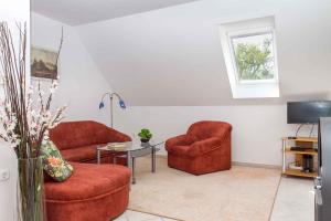 ein Wohnzimmer mit 2 roten Stühlen und einem Tisch in der Unterkunft Apartment in Balatonmariafürdo 19551 in Balatonmáriafürdő