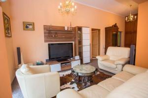 Il comprend un salon doté d'un mobilier blanc et d'une télévision à écran plat. dans l'établissement Apartment in Porec/Istrien 39700, à Poreč