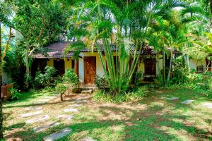 a house with palm trees in front of it at La Mer Resort, Phú Quốc in Phú Quốc