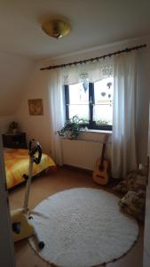 a bedroom with a bed and a window with two guitars at Apartment in Eibenstock 30354 in Eibenstock