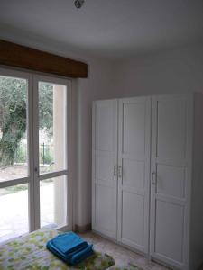 um quarto com armários brancos, uma cama e uma janela em Holiday home in Roggio 37057 em Testico