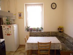 Holiday home in Siofok/Balaton 38173 في سيوفوك: مطبخ مع طاولة وثلاجة ونافذة