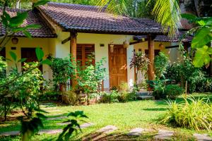 a house with a door in a garden at La Mer Resort, Phú Quốc in Phú Quốc