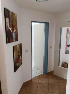 a hallway with a mirror and paintings on the wall at Apartment in Sellin/Insel Rügen 37917 in Sandort