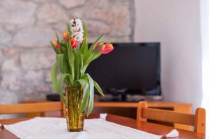 a vase of flowers sitting on a table at Apartment in Stivan/Insel Cres 37906 in Štivan