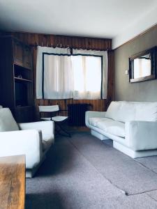 una sala de estar con 2 sofás blancos y una ventana en Cabaña Departamento CERRO CATEDRAL Mínimo 5 NOCHES en San Carlos de Bariloche