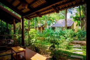 a view of a garden from the porch of a house at La Mer Resort, Phú Quốc in Phú Quốc