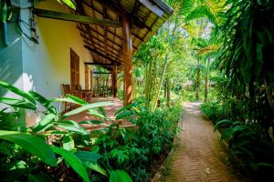 a garden with a pathway leading to a house at La Mer Resort, Phú Quốc in Phú Quốc