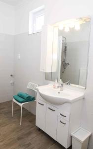 a white bathroom with a sink and a mirror at Holiday home in Balatonkeresztur 37078 in Balatonkeresztúr +27 photos