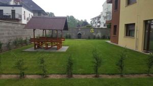 a wooden bench in a yard with a gazebo at Apartments in Siofok - Balaton 38420 in Siófok